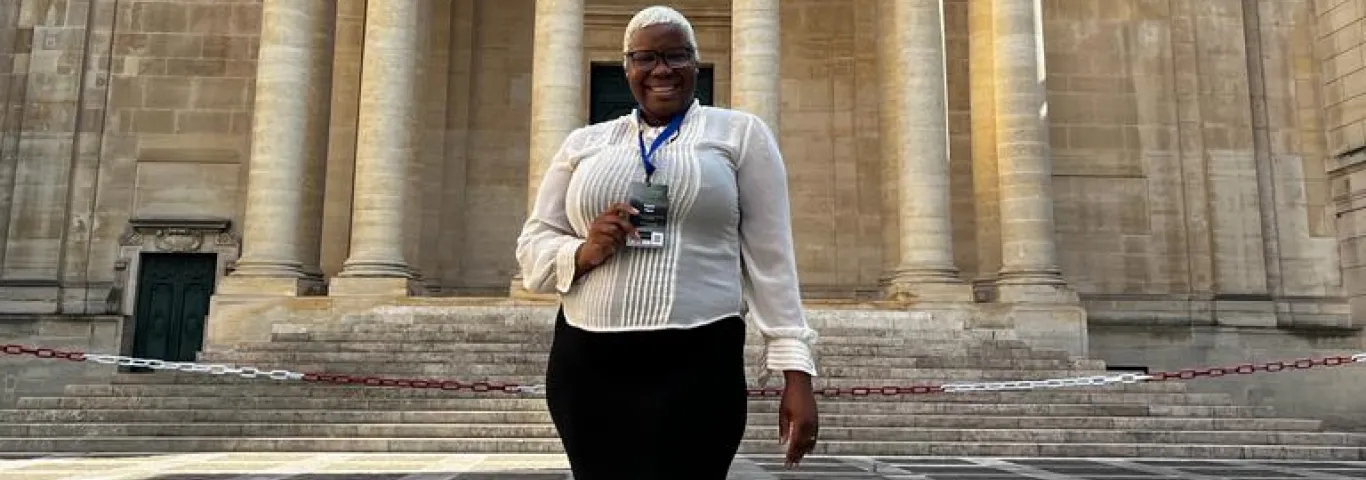Crystal Payne standing in front of a Sorbonne Université building with Certificate.