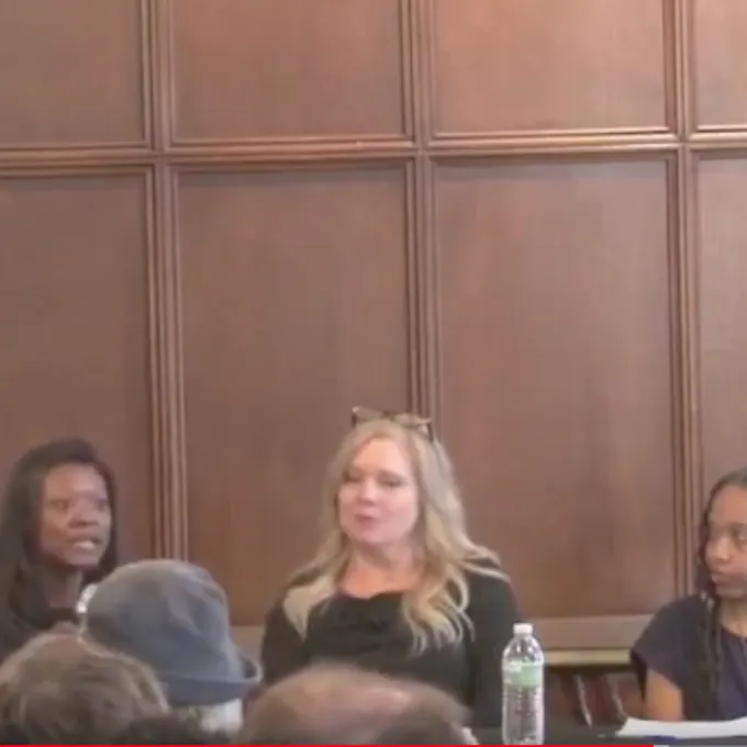 3 panelists at table with microphones